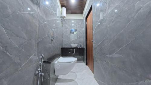a bathroom with a toilet and a sink at Hotel Otel Besa in Nagpur