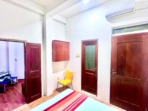 a room with two doors and a yellow chair at Studio Greenlands 2nd-E in Battaramulla