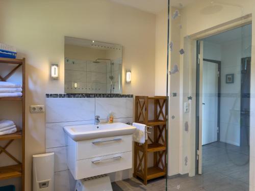 a bathroom with a white sink and a mirror at Objekt-Nr 237 - Priwall - Mecklenburger Landstraße in Priwall