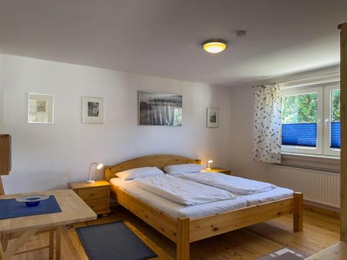 a bedroom with a large bed and a table at Objekt-Nr 237 - Priwall - Mecklenburger Landstraße in Priwall