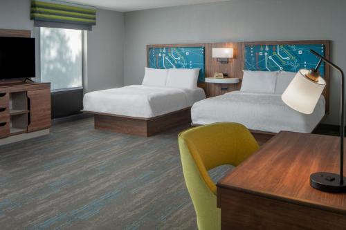 a hotel room with two beds and a television at Hampton Inn Enterprise in Enterprise