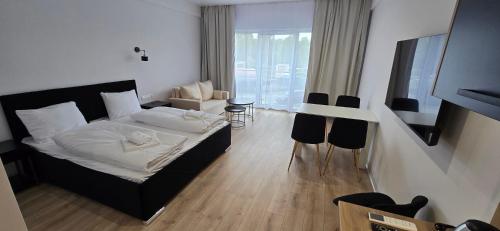 a bedroom with a bed and a table and chairs at White Pearls Apartaments Dąbki in Dąbki