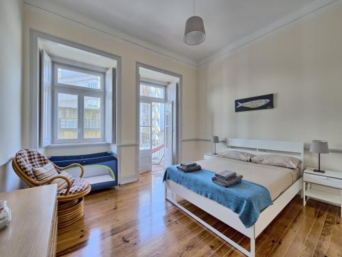 ein Schlafzimmer mit einem Bett, einem Tisch und einem Stuhl in der Unterkunft Almirante Reis Apartment in Lissabon