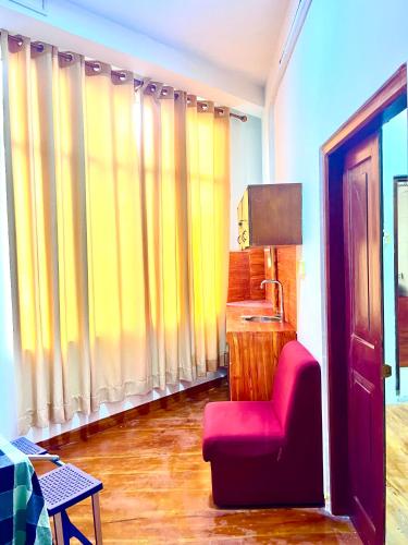 a living room with a red chair and a lamp at Studio Greenlands 2nd-E in Battaramulla