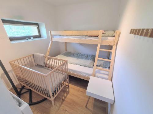 a small room with a bunk bed and a chair at Apartmán na Špičáku in Špičák
