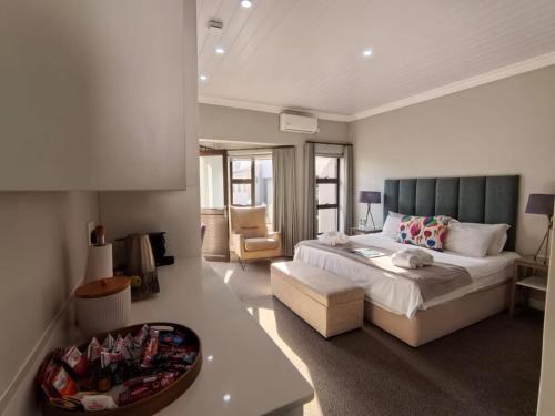 a bedroom with a large bed and a couch at Bay Lodge on the Beach in Mossel Bay