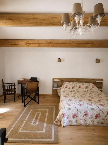 a bedroom with a bed and a desk at Atelier Provençal in La Celle-sous-Gouzon