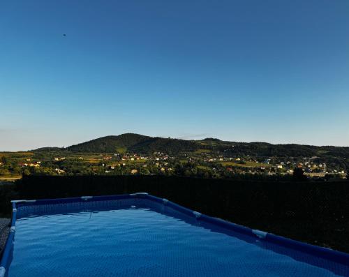 a blue swimming pool with a view of a city at Cottage Soul Rest in Visoko