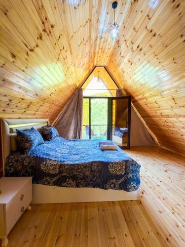 a bedroom with a bed in a wooden house at Lerik Forest House in Lerik
