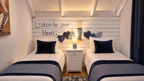 two beds sitting next to each other in a room at Be Our Guest Self Catering in Nelspruit
