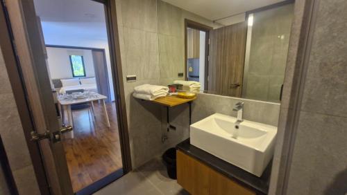 a bathroom with a sink and a mirror at Stasia Suites Sriracha in Ban Fang Daeng