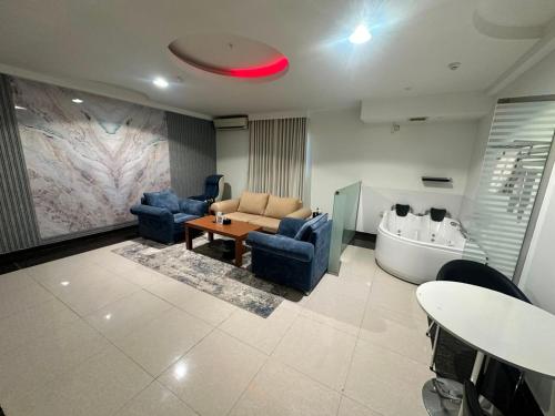 a living room with couches and a table and a tub at فندق روز أوسيس - Roz Oasis Hotel in Najran