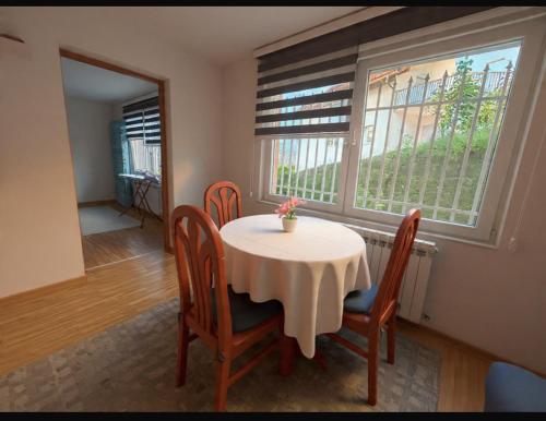 a dining room with a table and chairs and a window at Close to SCC Luxury apartment in Sarajevo in Sarajevo