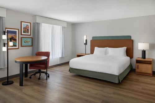 a hotel room with a bed and a desk and a table at Hampton Inn by Hilton Odessa in Odessa