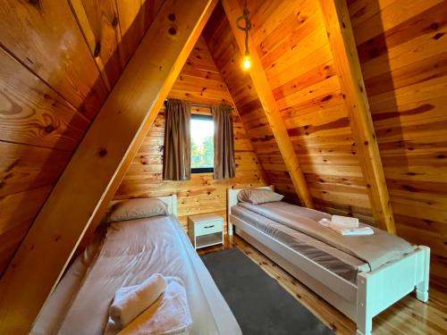 two beds in a room in a log cabin at Golden Horizon in Žabljak
