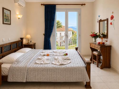 a bedroom with a bed with two towels on it at Des Roses Hotel in Platanias