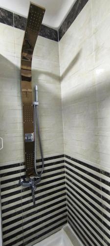 a shower in a bathroom with black and white stripes at kabila vista vuestra a la piscina Z6 in Martil