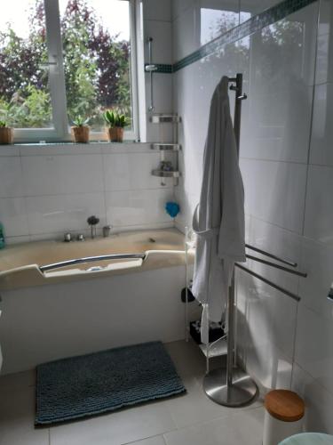 a bathroom with a tub and a sink and a window at Zen Olive Guest Room in Antwerp
