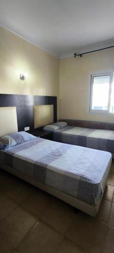 a bedroom with three beds in a room at kabila vista vuestra a la piscina Z6 in Martil