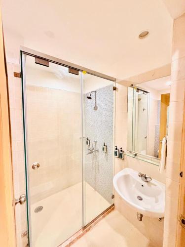 a bathroom with a glass shower and a sink at Mango Grove Hotel in Chandīgarh