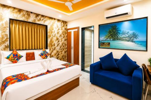 a bedroom with a bed and a blue chair at Agy Hotels in Pune