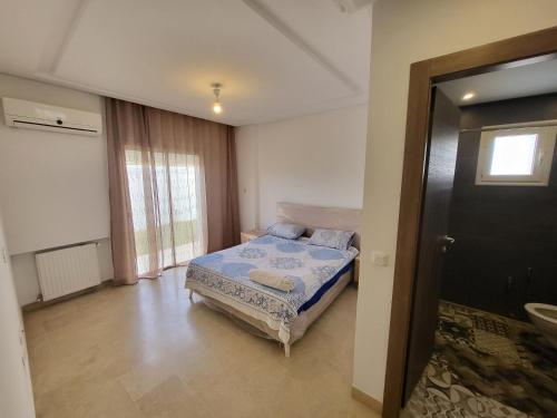 a bedroom with a bed and a window and a door at Luxuary pool appartement in La Marsa