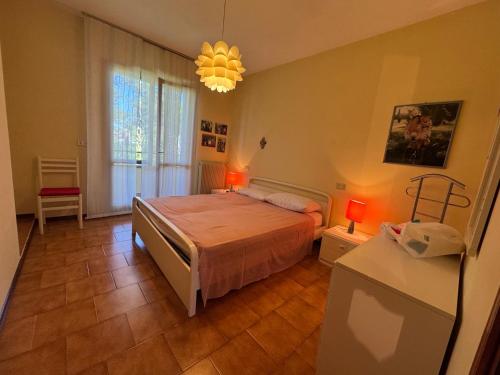a bedroom with a bed and a chandelier at Villa Dosso Fiorito in Lignano Sabbiadoro