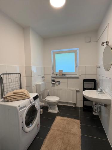 a bathroom with a washing machine and a sink at WeLiving Apartments in Weinheim
