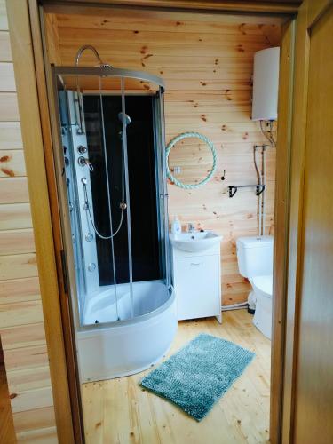a bathroom with a shower and a sink at Chata z Pary in Giby