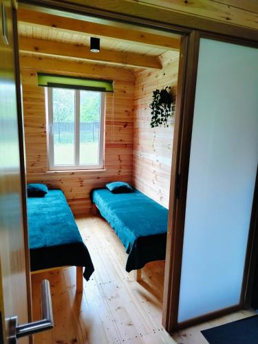 a room with two beds in a log cabin at Chata z Pary in Giby
