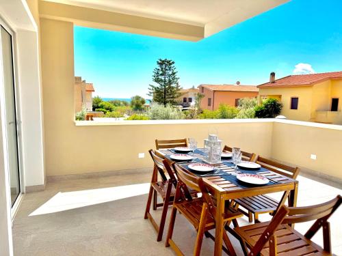 a dining room with a table and chairs on a balcony at Blu Mare Pregiata Villa con terrazza vista mare in La Maddalena