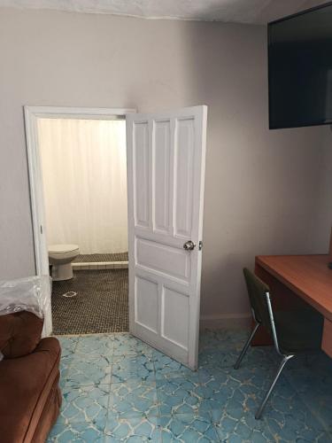 a room with a door and a couch and a desk at Studio Azul in Tlaxcala de Xicohténcatl