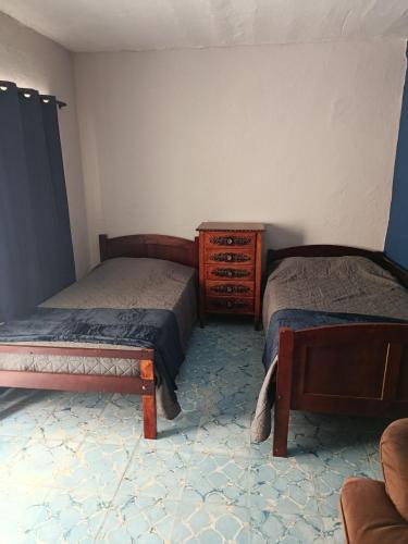 a bedroom with two twin beds and a dresser at Studio Azul in Tlaxcala de Xicohténcatl