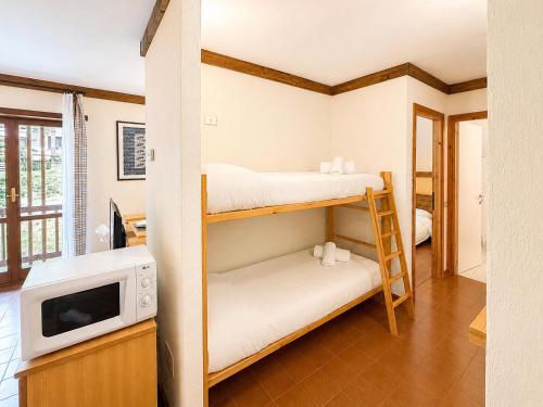 a room with two bunk beds and a microwave at Hostdomus - A3-24 in Grange Sises