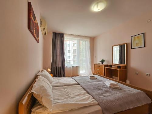 a bedroom with a bed and a dresser and a window at Marina and Panorama Apartments in Sveti Vlas