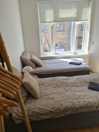 two beds in a room with a window at Damm Hotell in Frederikshavn
