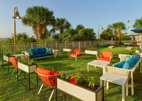 a group of chairs and tables in a yard at Hampton Inn & Suites Myrtle Beach Oceanfront in Myrtle Beach