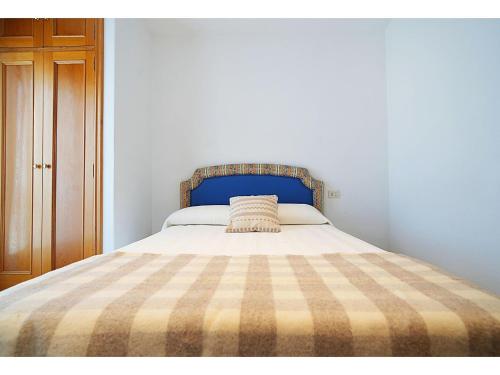 a bed with a plaid blanket on top of it at GALIHOST - Casa Chouba, frente a la playa in Sanxenxo