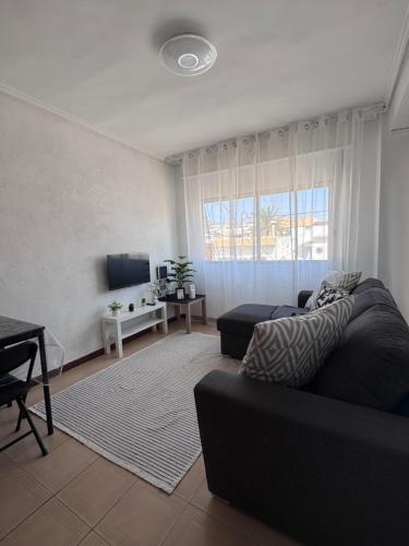 a living room with a couch and a tv at La casa de la Brisa in Piles
