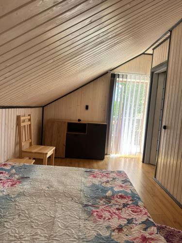 a bedroom with a bed and a table and a window at Білий птаха in Svityazʼ