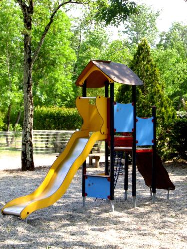 - une aire de jeux avec un toboggan et 2 chaises dans l'établissement Camping La Digue, à Chauzon