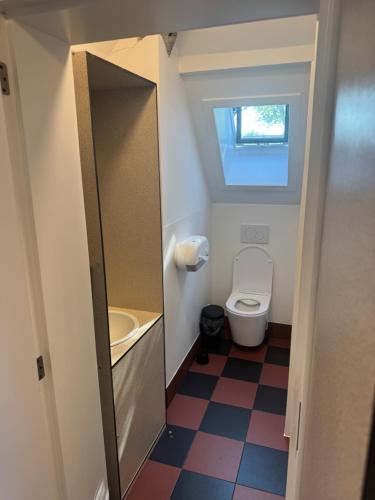 a small bathroom with a toilet and a sink at Horizon Hostel in Bredene