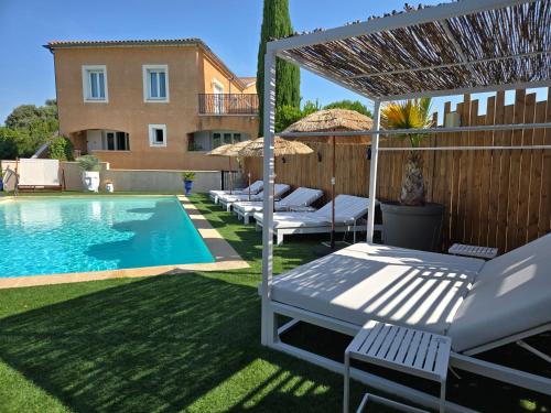 a backyard with a swimming pool and a house at Hôtel Le SAINT-GENIÈS in Uzès