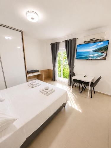 a bedroom with a bed and a desk and a table at Apartments & Rooms Prižmić in Podstrana