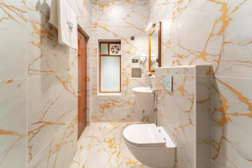 a bathroom with a toilet and a sink at Hotel Palais De Versailles in Pondicherry