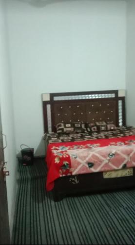 a bedroom with a bed with a red comforter at Eighty eight restaurant and cafe in Muzaffarnagar