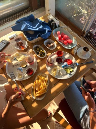 people sitting around a wooden table with plates of food at DORTMEVSİM Hotel in Bodrum City