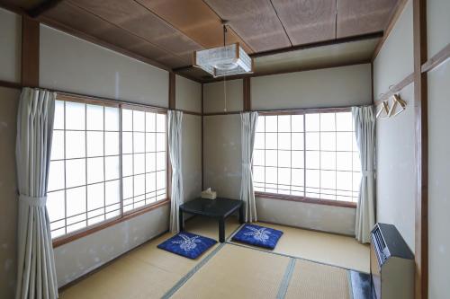 a room with two large windows and a table at Saunalodge 白道 in Minami Uonuma