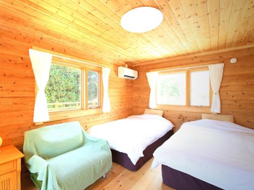 a bedroom with two beds in a wooden cabin at 石垣島コテージAkeeesi365 LOG in Ishigaki Island