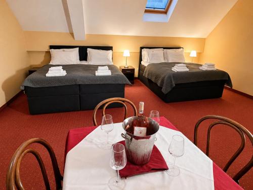 a room with two beds and two tables with wine glasses at Rooms Villa Iva in Ilok